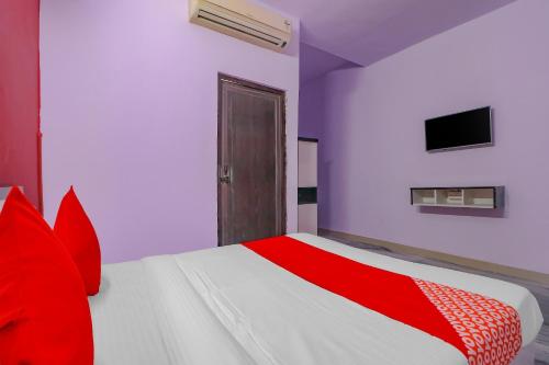 a bedroom with a red and white bed and a tv at Primrose Hotel's Near Noida Sector Metro Station in Noida