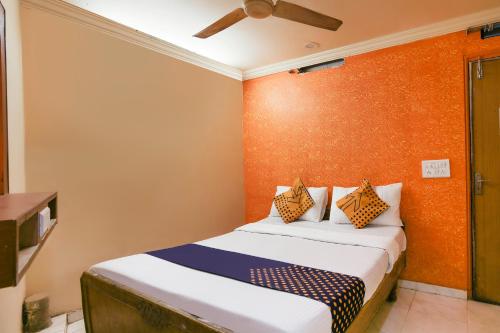 a bedroom with a bed and a ceiling fan at SPOT ON Hotel Super Guest House in Ahmedabad