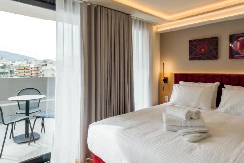 a hotel room with a bed with towels on it at Urban Frame Acropolis in Athens