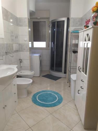 uma casa de banho com um chuveiro, um WC e um lavatório. em Light Blue Room em Scordia