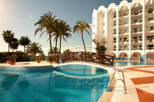 
a large swimming pool in front of a large building at Marinas de Nerja Beach & Spa in Nerja
