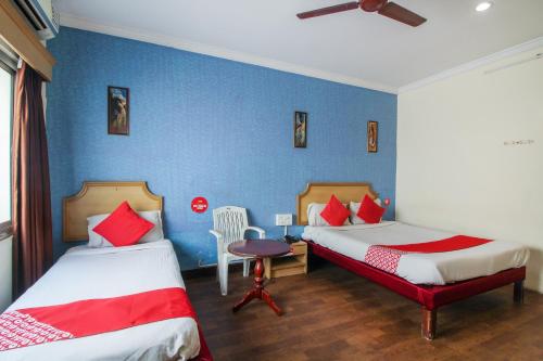 OYO Luxury Villas Near Begumpet Airport في Ameerpet: غرفة نوم بسريرين وجدار ازرق