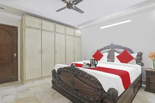 a bedroom with a large bed with red pillows at Alpine Glow Crest in Secunderabad