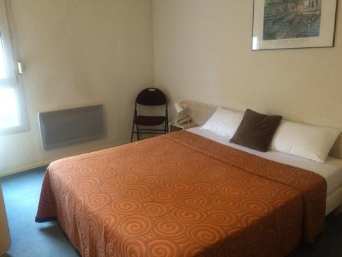 a bedroom with a bed and a chair in it at Anne De Beaujeu in Gien