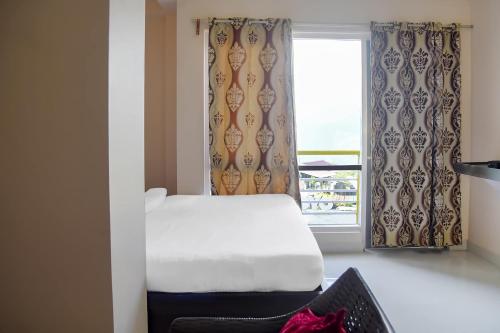 a bedroom with a bed and a window at Collection O Hotel Tashi Tenka in Gangtok