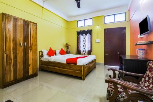1 dormitorio con cama, escritorio y silla en OYO Alohi Ghar, en Bhutiāgāon