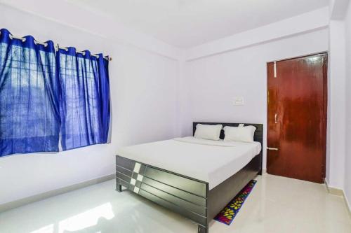 a white bedroom with a bed and a window at Flagship Hotel Paradise Inn in Patna