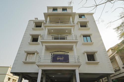 um edifício branco alto com um cartaz em Capital O La Grace Premium em Khandagiri