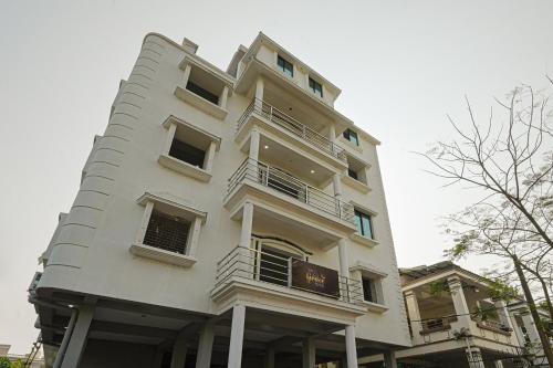 um edifício branco alto com um cartaz em Capital O La Grace Premium em Khandagiri