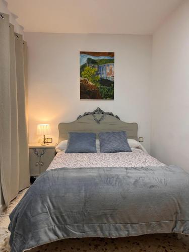 a bedroom with a large bed with two blue pillows at LA COLMENA in Cañizares