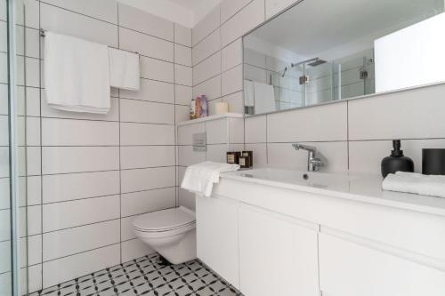 a white bathroom with a toilet and a sink at HaKerem new luxury 3 rooms apartments and 2 rooms penthaus in Tel Aviv