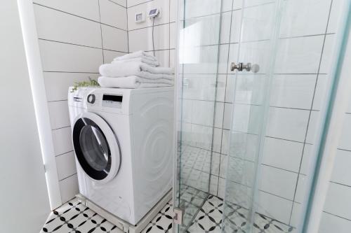 a washing machine in a bathroom with a shower at HaKerem new luxury 3 rooms apartments and 2 rooms penthaus in Tel Aviv