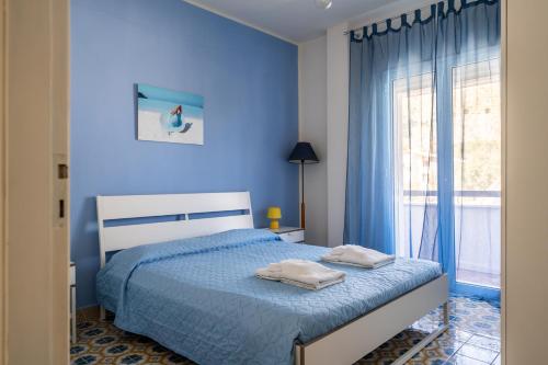 a blue bedroom with a bed and a window at La Maison De Provence - MONDELLO in Mondello