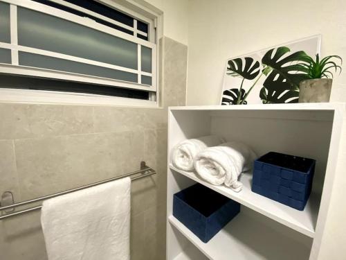 a bathroom with a towel shelf and a window at Private 3BR Tropical Paradise near Oistins in Christ Church