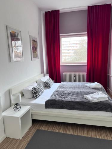sypialnia z dużym łóżkiem z czerwonymi zasłonami w obiekcie Apartment & Boardinghouse Berlin Friedrichshain-Kreuzberg w Berlinie