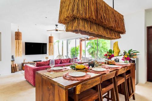 sala de estar con mesa de madera y sofá rojo en Villa Ek'Balam & Villa Flamingo, Luxury Villas, Private Pool, Private Garden, Jacuzzi, 24h Security en Tulum