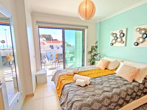 a bedroom with a large bed with a large window at Beach Condo with Atlantic Ocean View by BeCherish in Olhos de Água