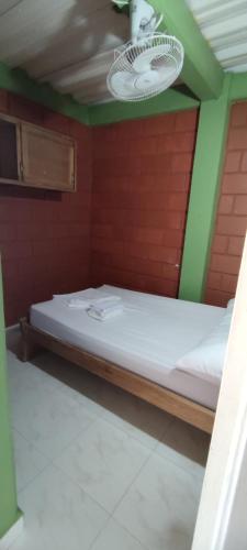 a bed in a room with a red wall at Mi pueblo natal Aptos y habitaciones in Necoclí