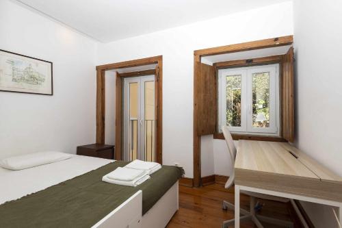 a bedroom with a bed and a desk and a window at Typical Portuguese Apartment in São Bento in Lisbon