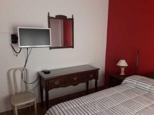 ein Schlafzimmer mit einem Bett und einem Fernseher an der Wand in der Unterkunft Apart Pm Albatros in Necochea