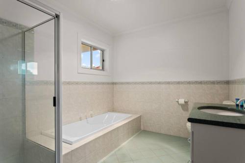 a bathroom with a bath tub and a sink at Waterfront Townhouse - Picturesque Marina Views in Port Lincoln