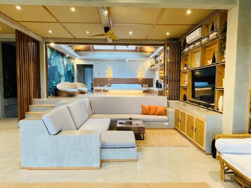 an open living room with a white couch and a kitchen at Ricehaven Luxury Villas with Starlink WIFI in General Luna