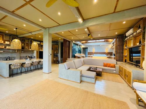 a living room with a couch and a kitchen at Ricehaven Luxury Villas with Starlink WIFI in General Luna