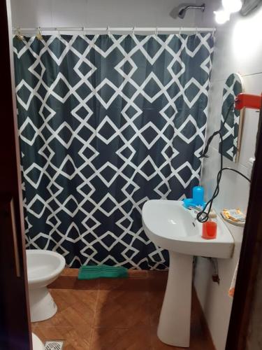 uma casa de banho com um WC branco e um lavatório. em Departamentos alvear em Esquel