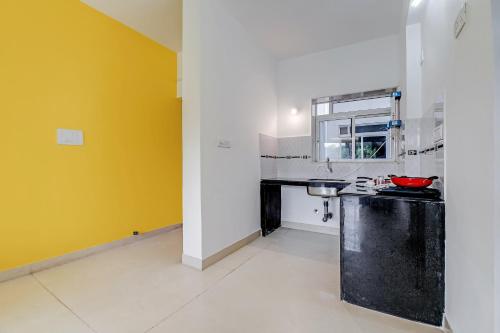 a kitchen with a counter and a yellow wall at OYO Home Hotel Sea Prince Suites in Dona Paula