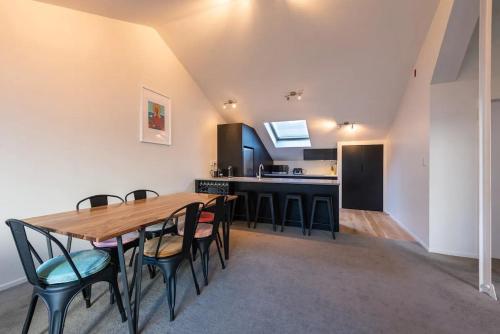 a kitchen and dining room with a wooden table and chairs at Inner City Apartment in Wellington