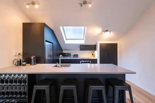a kitchen with a counter with bar stools and a sink at Inner City Apartment in Wellington