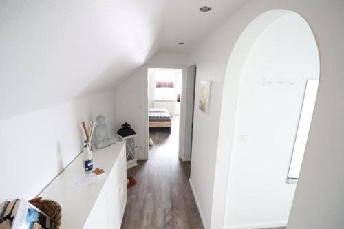 Cette chambre dispose de murs blancs et d'un couloir blanc. dans l'établissement Appartementhaus-Kogge-Wohnung-7, à Cuxhaven