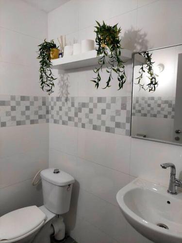 a white bathroom with a toilet and a sink at Уютная 2-х комнатная квартира недалеко от моря in Ashdod