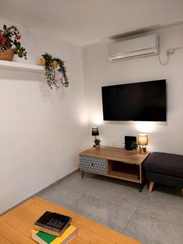 a living room with a flat screen tv on the wall at Уютная 2-х комнатная квартира недалеко от моря in Ashdod