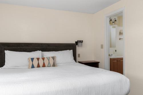 a bedroom with a large white bed with a pillow at The Beverly in Beverly