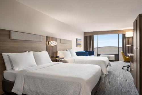 Cette chambre comprend 2 lits et une fenêtre. dans l'établissement Holiday Inn Express & Suites East Greenbush Albany-Skyline an IHG Hotel, à Rensselaer