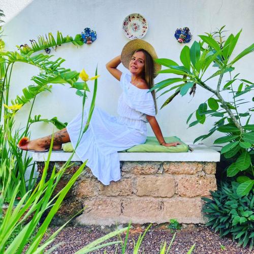 a woman sitting on a wall with a hat at Sriyan Villa in Beruwala