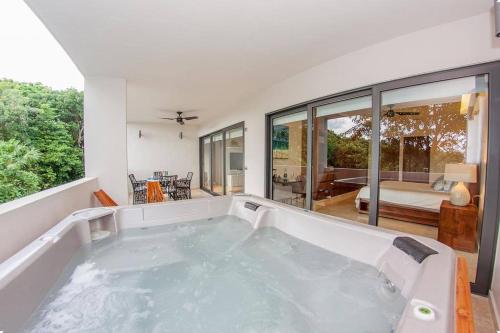 a jacuzzi tub in a room with a living room at Luxury Condo between 5th Avenue and the Beach in Playa del Carmen