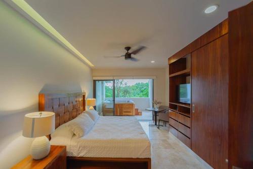 1 dormitorio con 1 cama grande y TV en Luxury Condo between 5th Avenue and the Beach, en Playa del Carmen