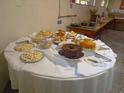 a table with many different types of food on it at Hotel Oscar Econômico Montes Claros in Montes Claros