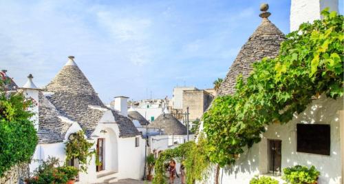 a row of white houses with trees and vines at LA DIMORA DEI SOGNI in Mesagne