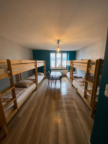 a room with three bunk beds and a table at Hostel 1902 in Zakopane