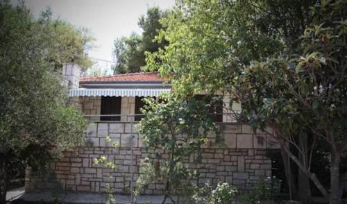 a brick building with a window and trees at Holiday Home Anja in Supetar