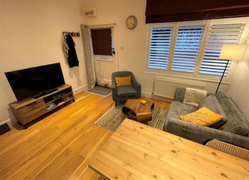 sala de estar con sofá y TV de pantalla plana en Peaceful Cottage for Two in Horsham en Horsham