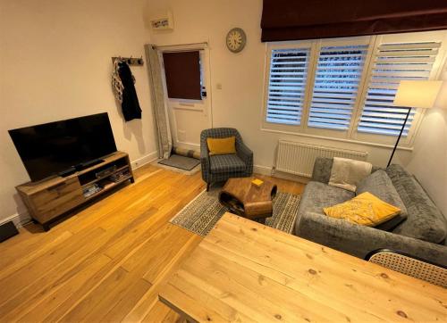 a living room with a couch and a flat screen tv at Peaceful Cottage for Two in Horsham in Horsham