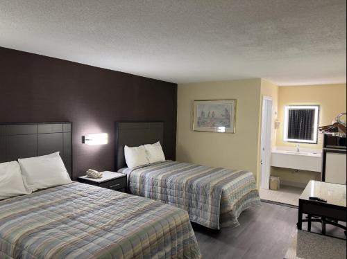 a hotel room with two beds and a sink at Travel Inn New Castle Airport in New Castle