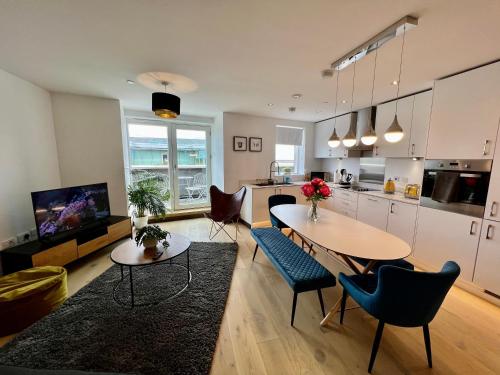 a kitchen and living room with a table and chairs at Walnut Tree Penthouse Next to Train Station in Cambridge