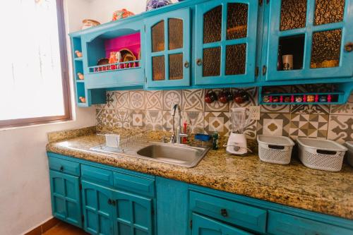 a kitchen with blue cabinets and a sink at Casa Oaxaqueña in Santa Cruz Huatulco