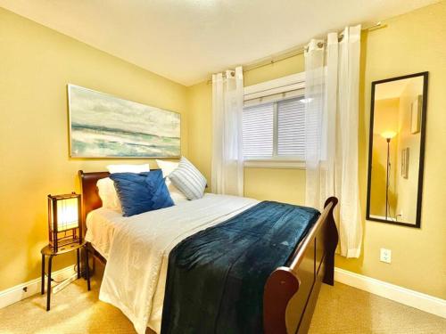 Un dormitorio con una cama con almohadas azules y una ventana en The Royal Suite en Surrey