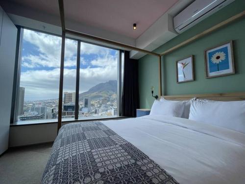 1 dormitorio con cama grande y ventana grande en City Center Penthouse with rooftop terrace en Ciudad del Cabo